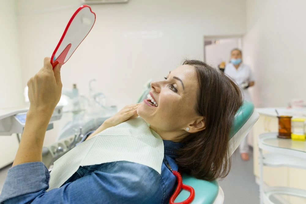 Patient seeing her smile with a mirror